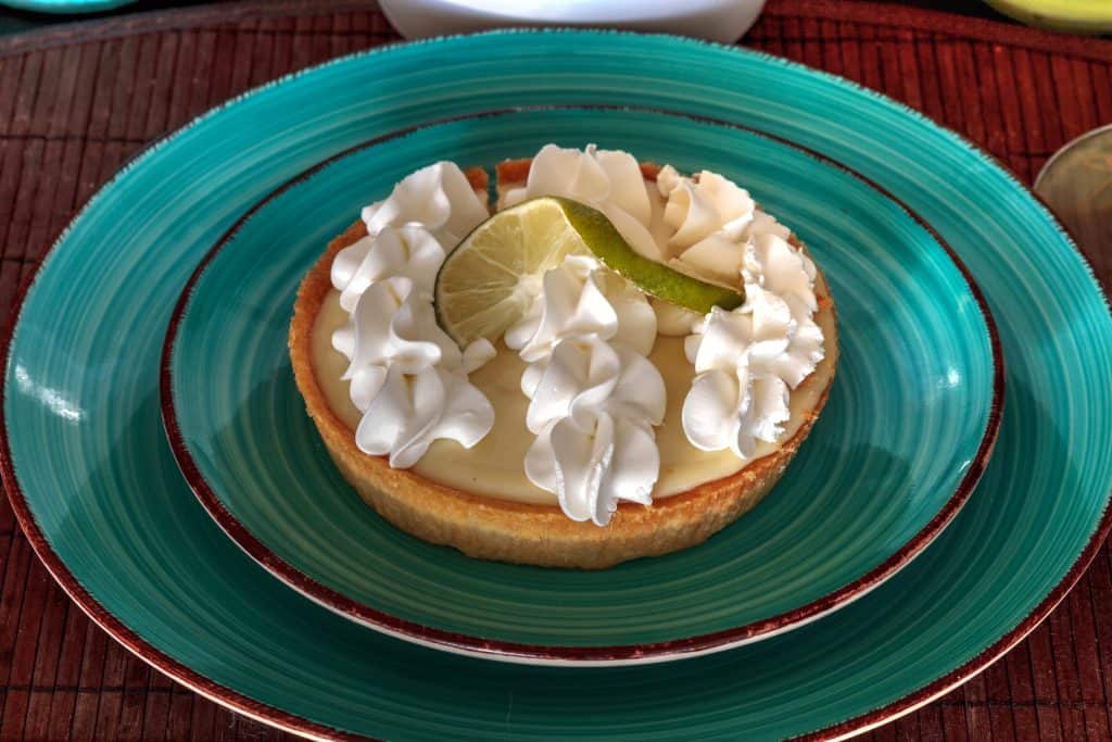 Photo of an individual sized Key Lime Pie on an aqua plate. 