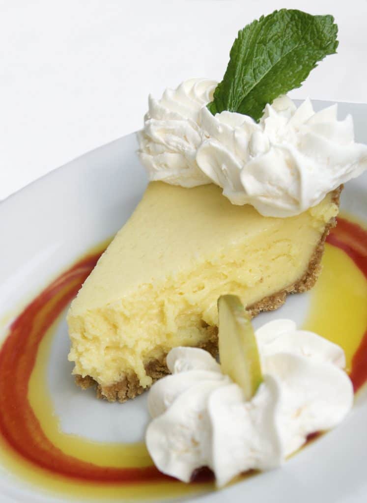 Photo of a slice of Key Lime Pie with a fruit swirl on the plate. 