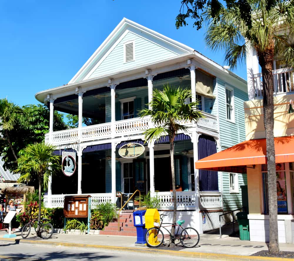 The light blue exterior of Bagatelle with palm trees.