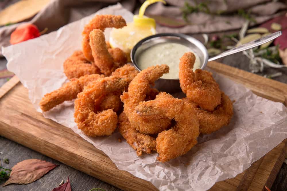 Fried shrimp with dipping sauce on wooden serving platter at one of the restaurants in Key West