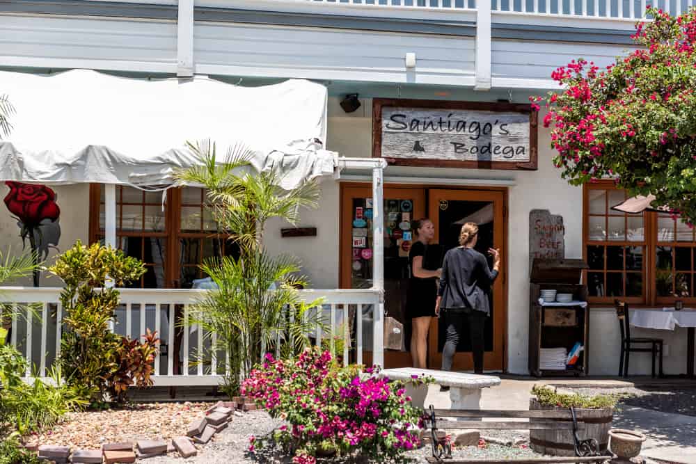 The white exterior of Santiago's Bodega with two people walking in