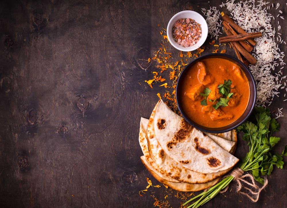 Indian curry with bread, parsley, and cinnamon, showcasing diversity in restaurants in Naples.