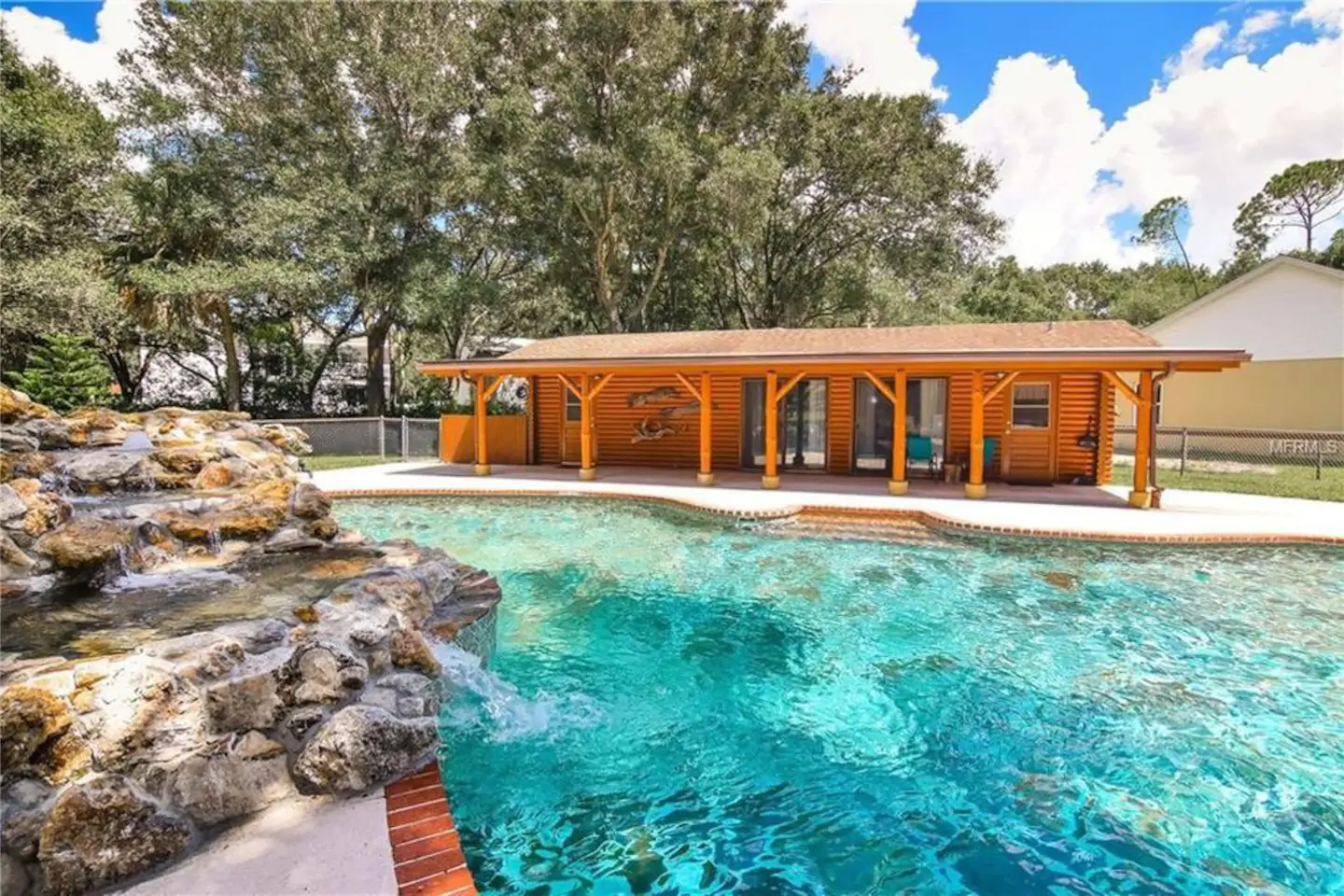 Photo of gorgeous poolside log cabin and bright blue pool at one of the best cabins in Florida.