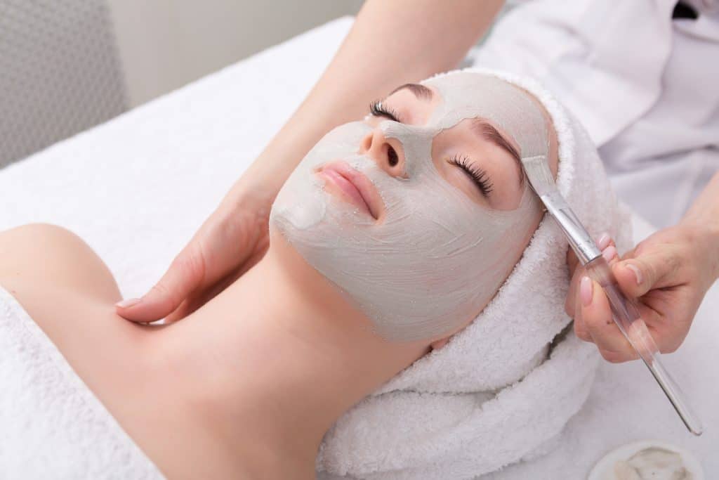 A mask treatment is applied with an exfoliating brush in one of the best spas in Florida.