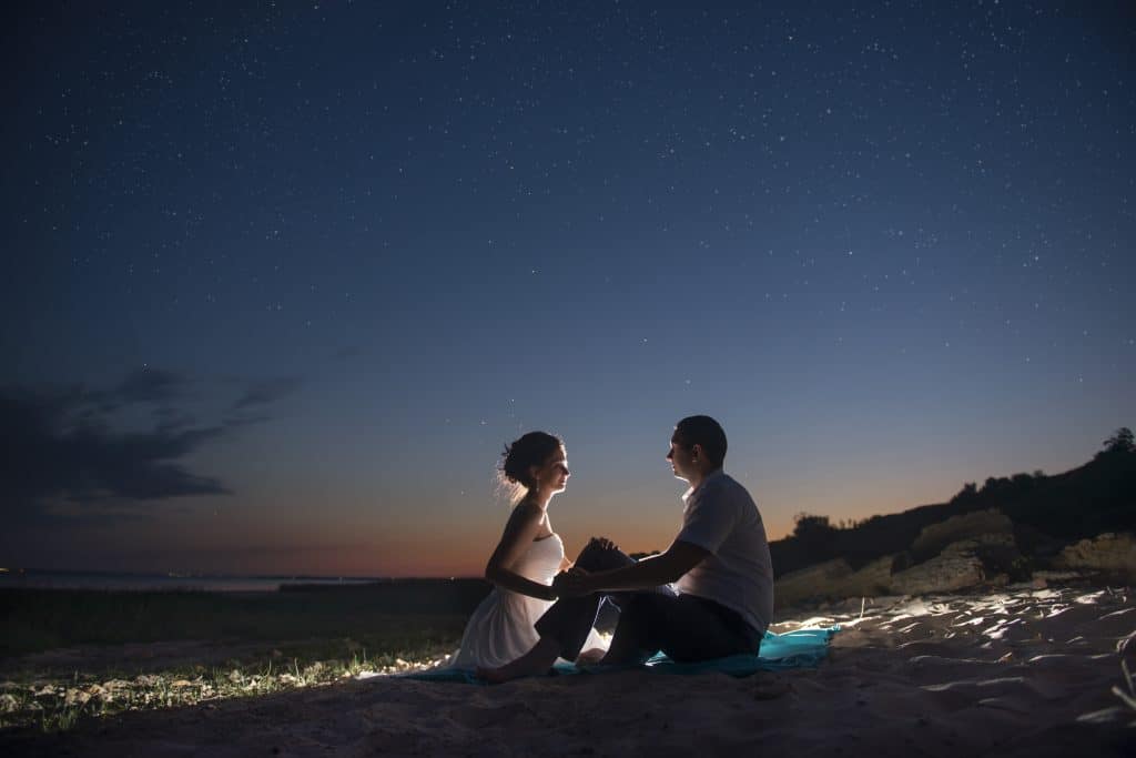 A couple enjoys a date night in Orlando on the water shoreline.