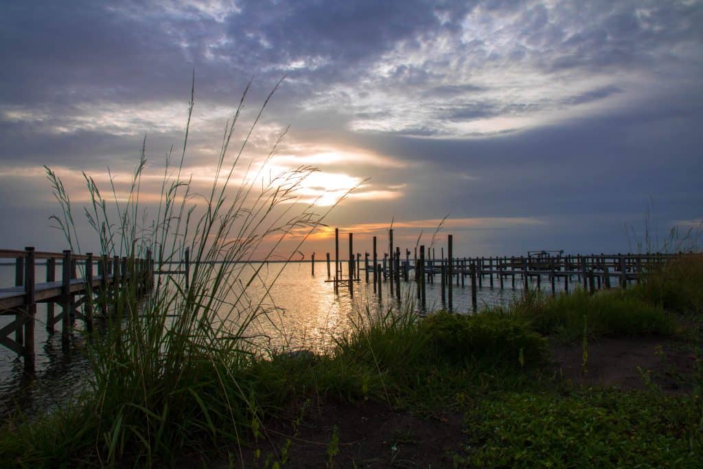 The shores of Indian River Lagoon at sunset, where you can see bioluminescence on the water, a perfect date night in Orlando. 