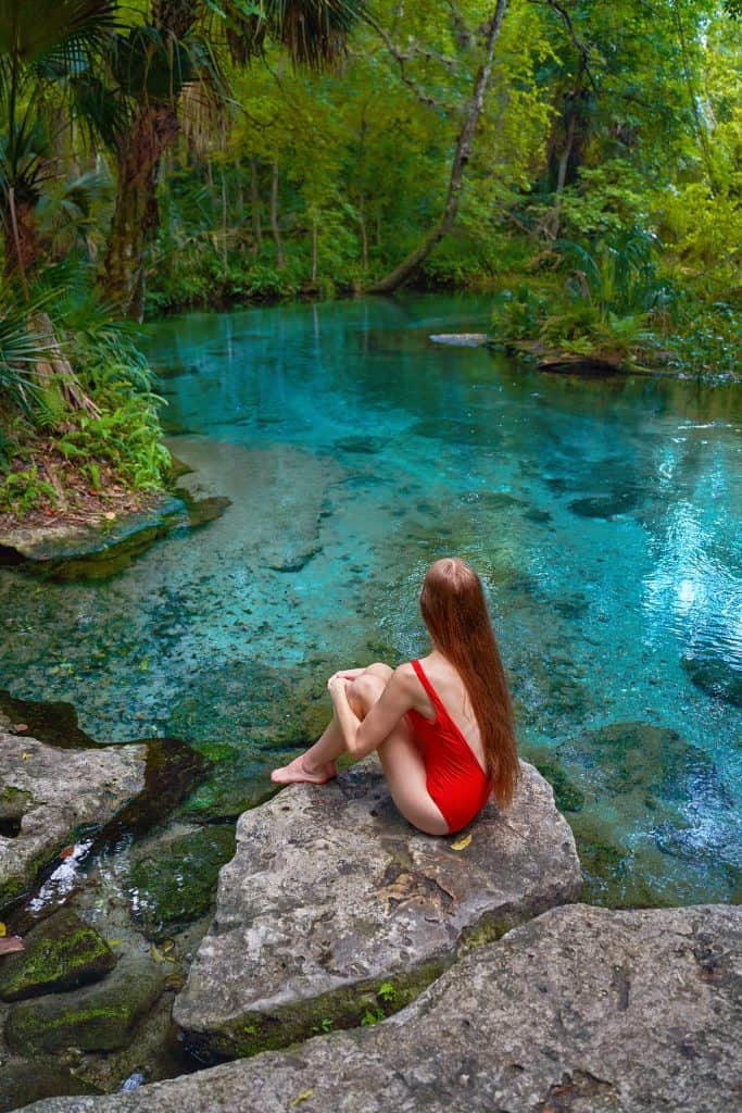 Victoria sits on a rock and gazes at the clear waters at Kelly Park/Rock Springs.