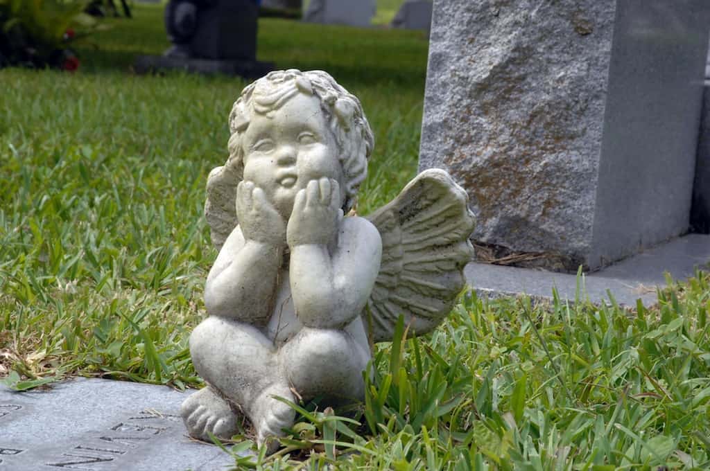 A cherub angel sits on a grave at the Greenwood Cemetery in Orlando, Florida.