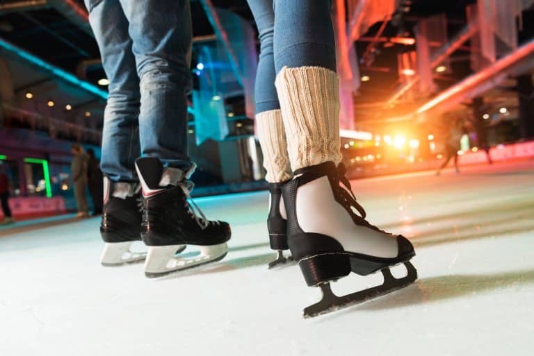 A couple ice skates in an indoor ice rink.