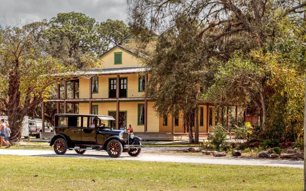 A vintage car sits outside a preserved building on the grounds of Koreshan State Park. 