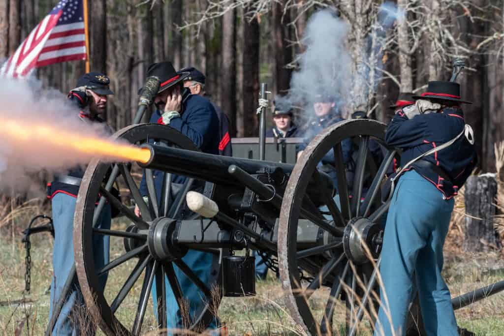 At a reenactment, soldiers fire a cannon at their enemies at Olustee Battlefield Historic State Park.