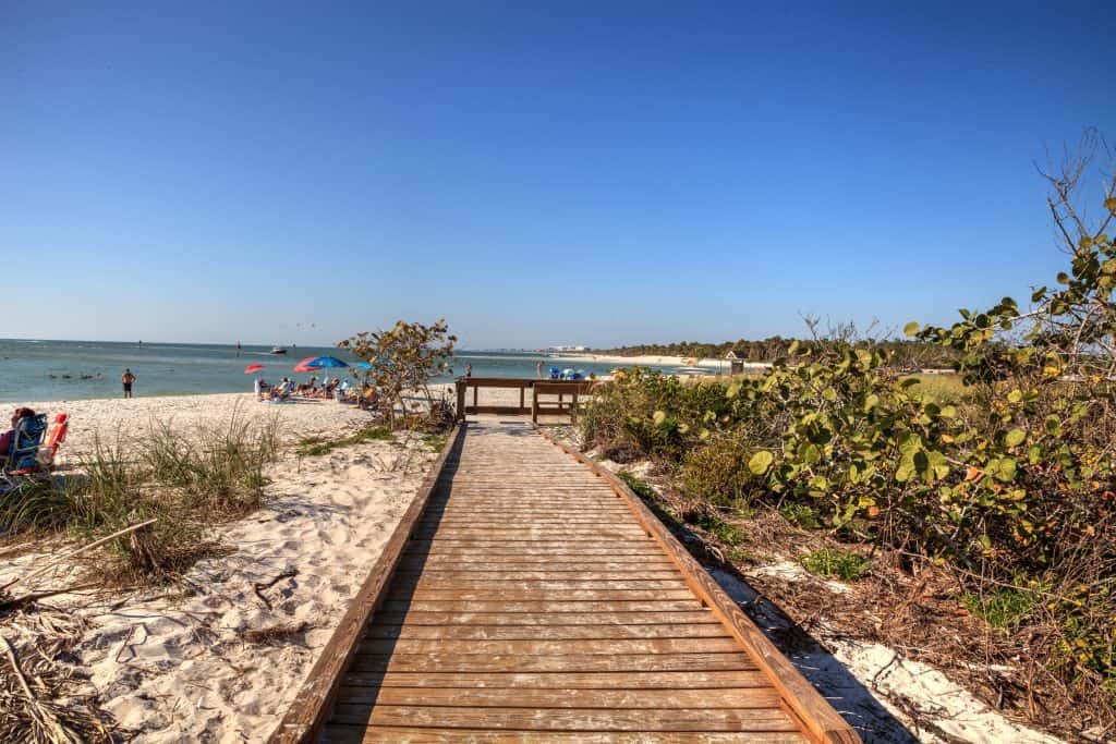 A boardwalk path leads the way to the beaches of Denlor-Wiggins Pass State Park, one of the most fun things to do in Naples.