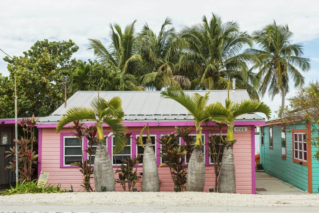 A pretty pink building sits among palm trees in Matlacha Village.
