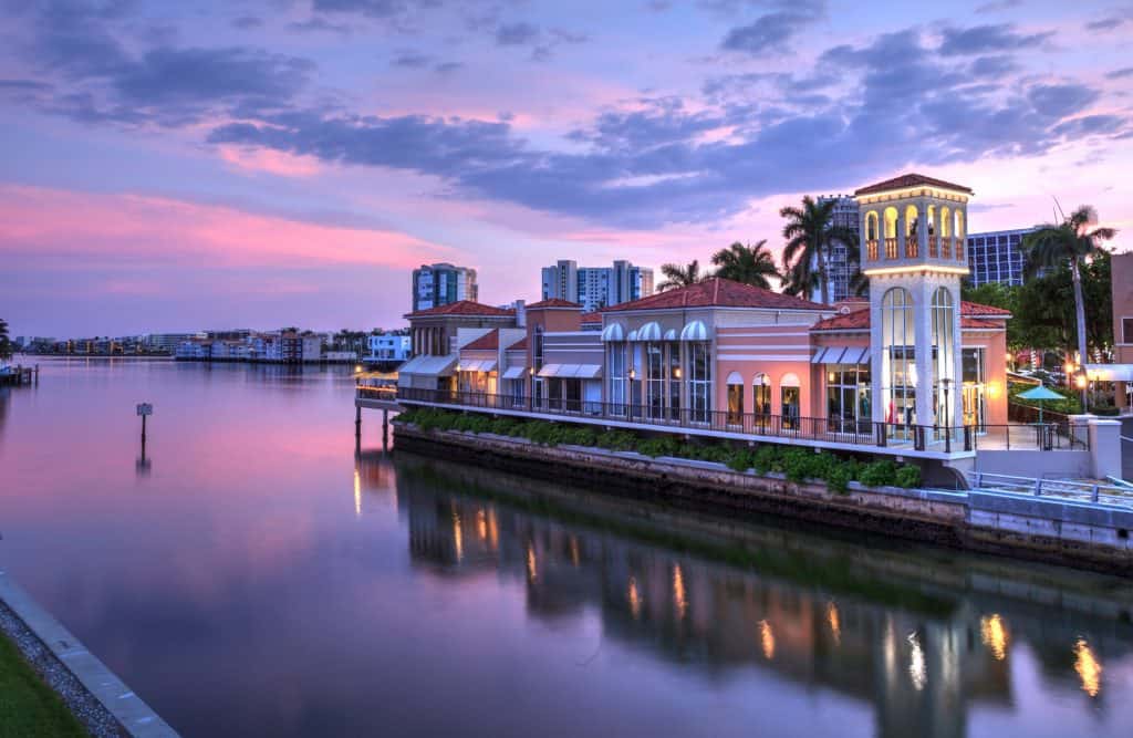 The shops in the Village on Venetian Bay overlook the water during sunset.