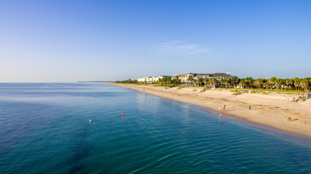 The beautiful blue waters and palm tree-lined beach of Spoil Island located on Indian River Lagoon in Vero Beach, FL.