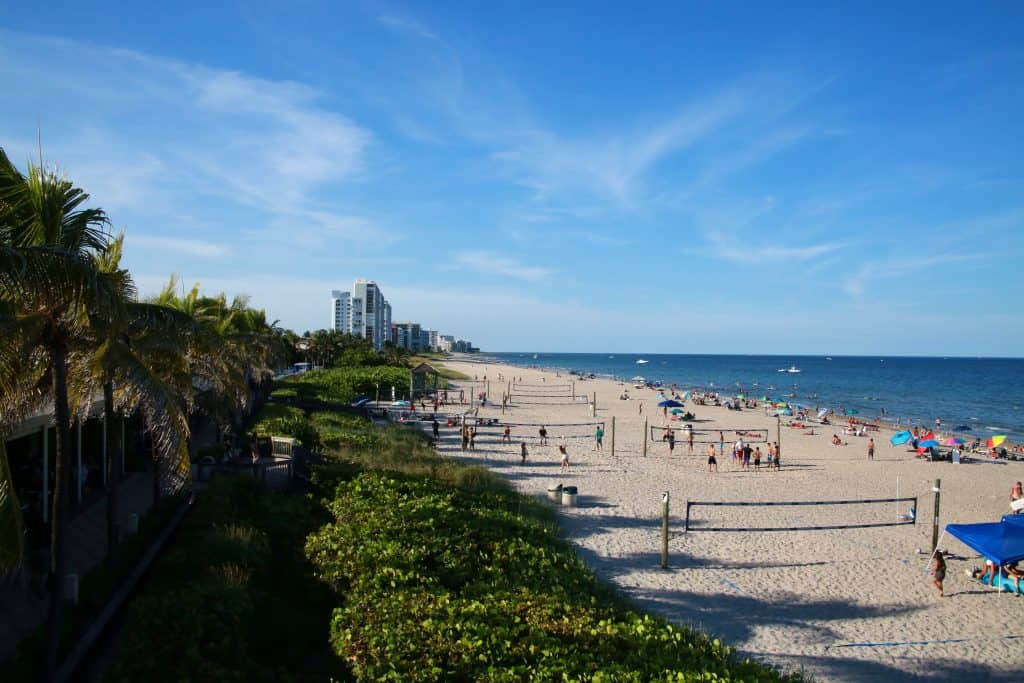 Families having fun and playing beach volleyball on the shores of Deerfield Beach. 