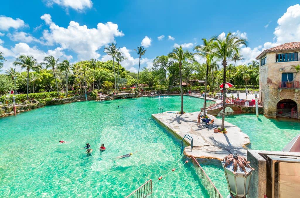 The Venetian Pool glitters and sparkles in the sunlight as swimmers enjoy its clear waters in Miami Florida.