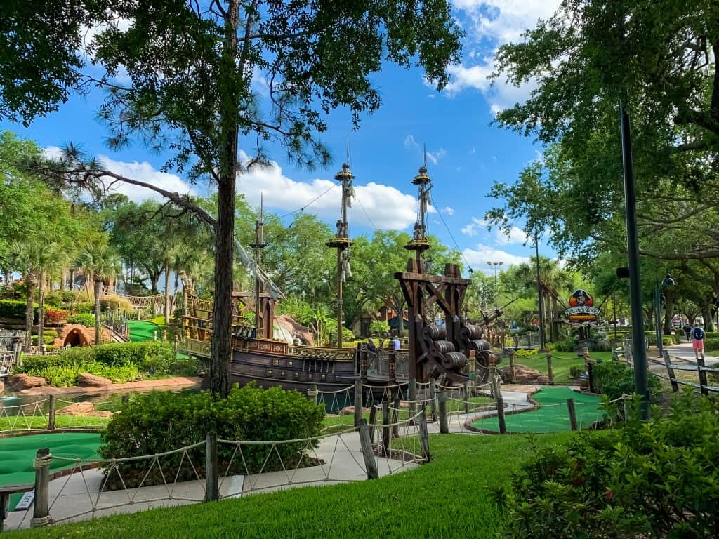 A family mini golfs through a buccaneer pirate ship at Pirate Cove Adventure Golf in Orlando, Florida. 