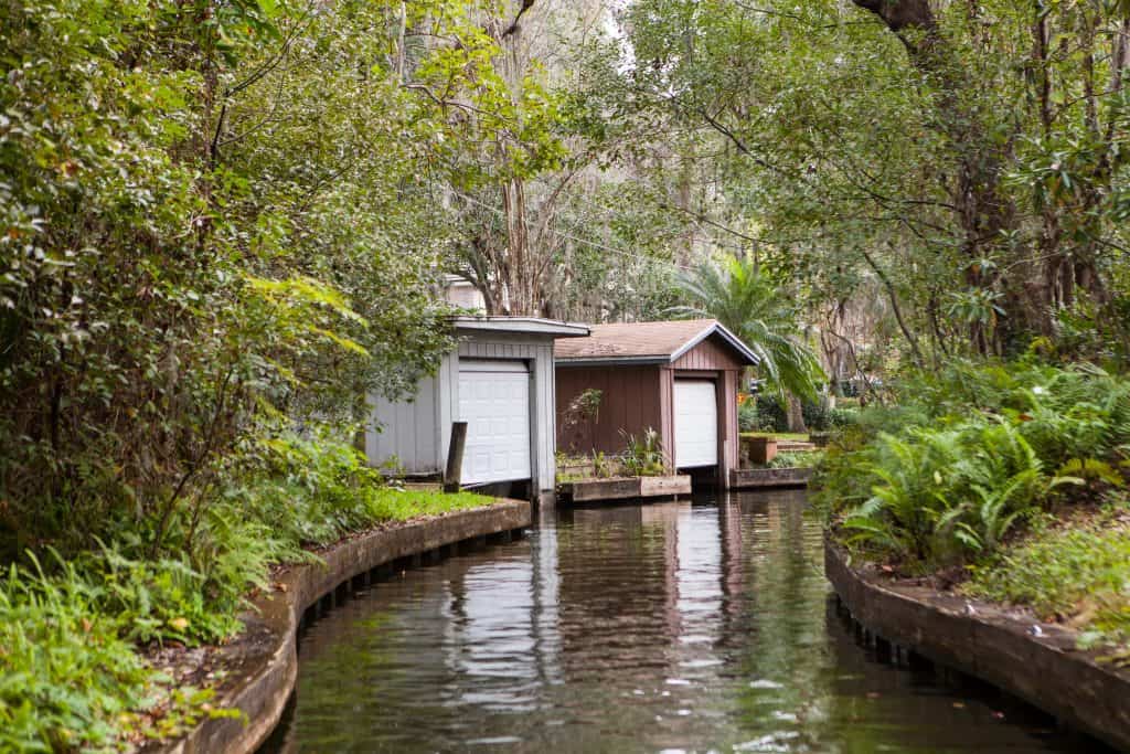 The view of boat sheds along a canal connecting the seven lakes of Winter Park, as seen from the Winter Park Scenic Boat Tour, one of the best things to do in Orlando.