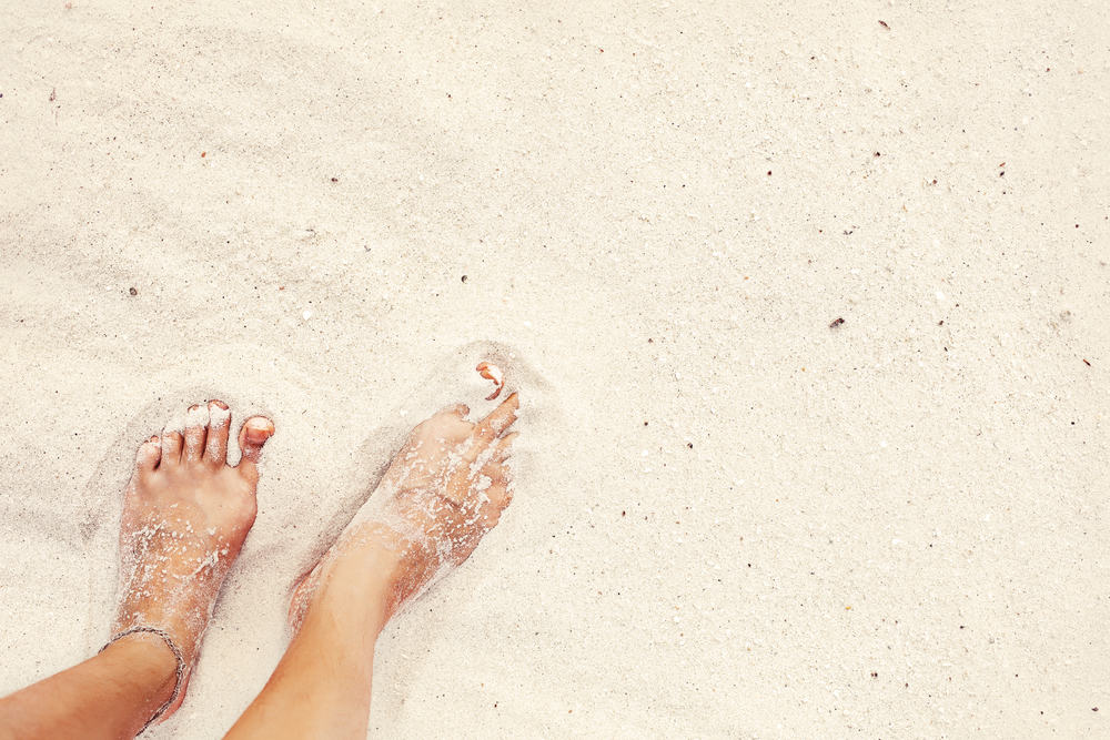 A female's feet in clean, white sand, which can be found at the best beaches in Key West.