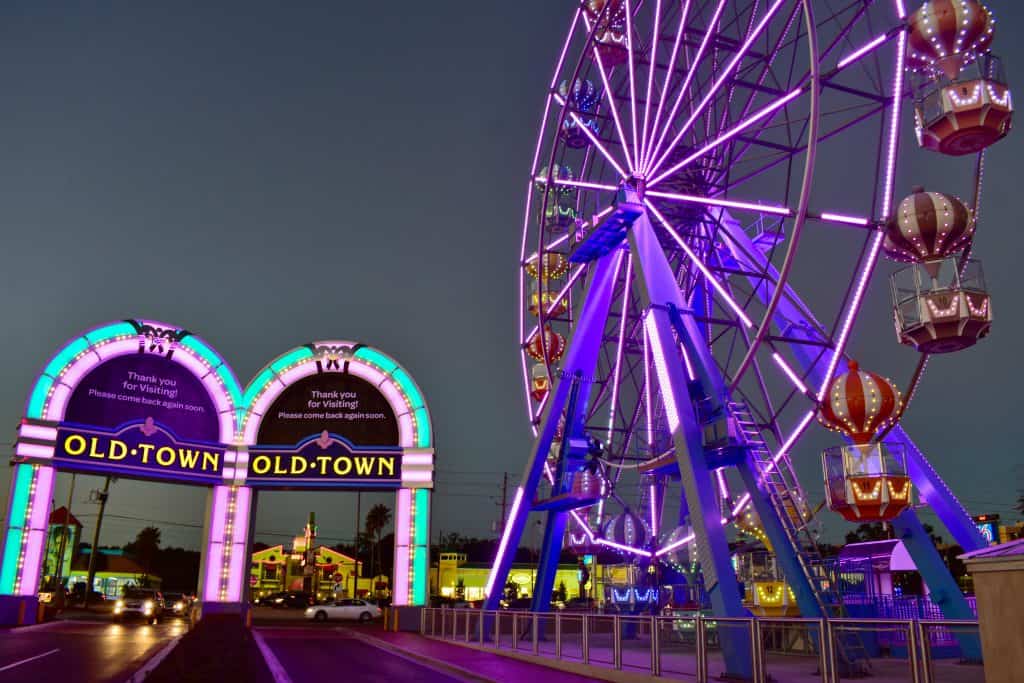 The entrance to Old Town is lined with pastel neon lights, right next to the iconic Ferris Wheel. 