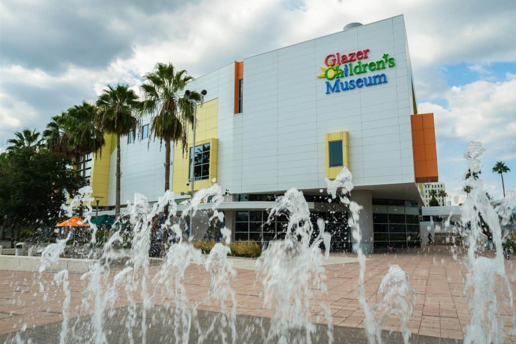 Fountains shoot water up from the ground in front of the Glazer Children's Museum, one of the best things to do during Christmas in Tampa.