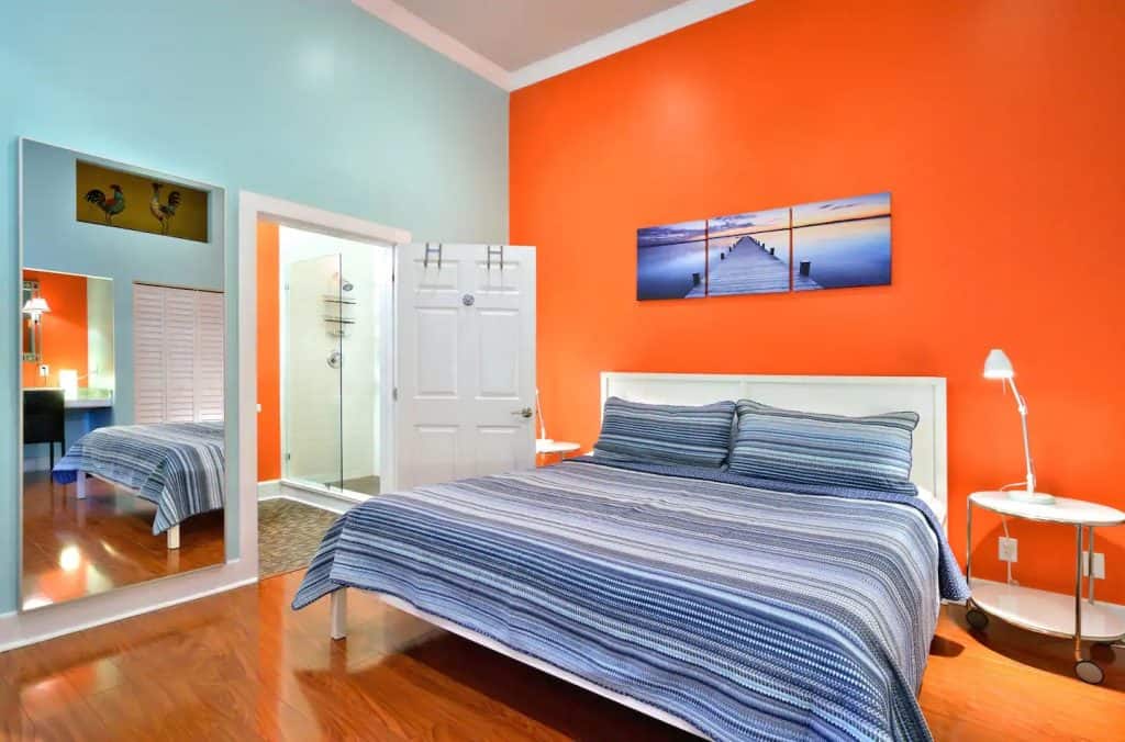 Photo of a bedroom with a bright orange accent wall at an Airbnb in Florida.