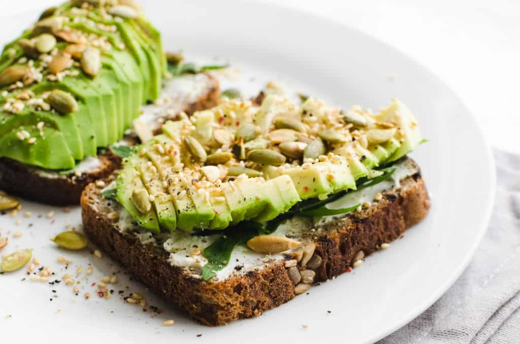 Whole grain toast is loaded with fresh avocado, perfect for a vegan breakfast in orlando