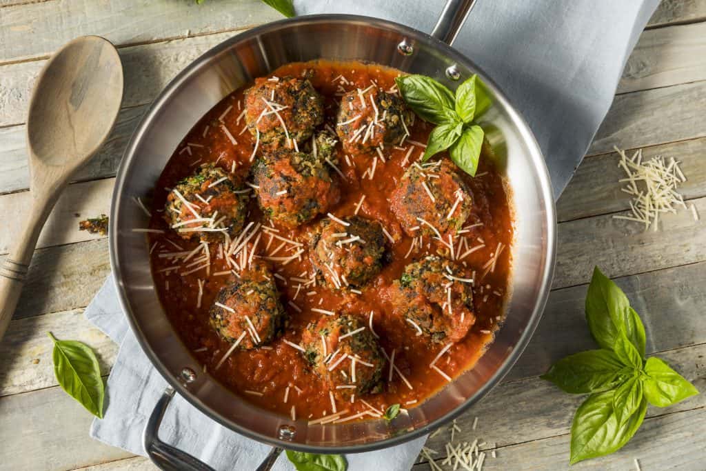 "Meatballs" simmer in a pan, making it easy to eat vegan in Orlando.