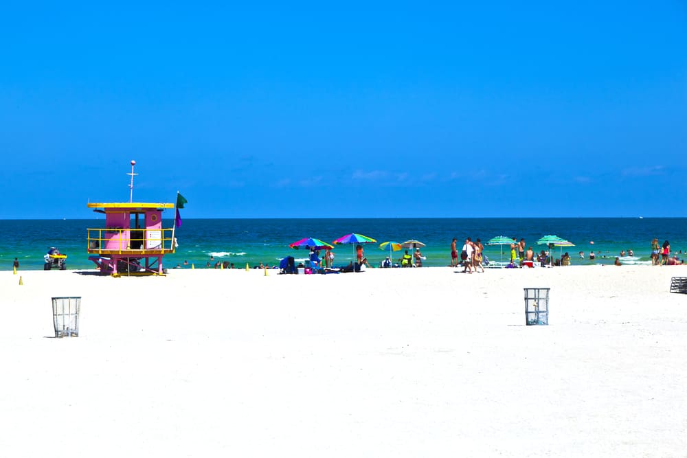 The white sand of North Beach with umbrellas and a lifeguard station.