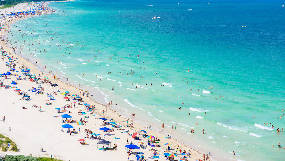 Aerial view of Surfside Beach with swimmers and sunbathers.