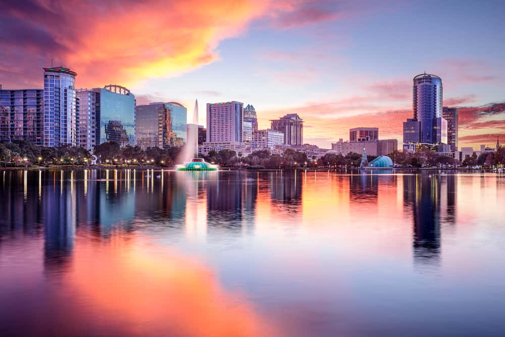 Sunset over a lake with the downtown Orlando skyline in the background.