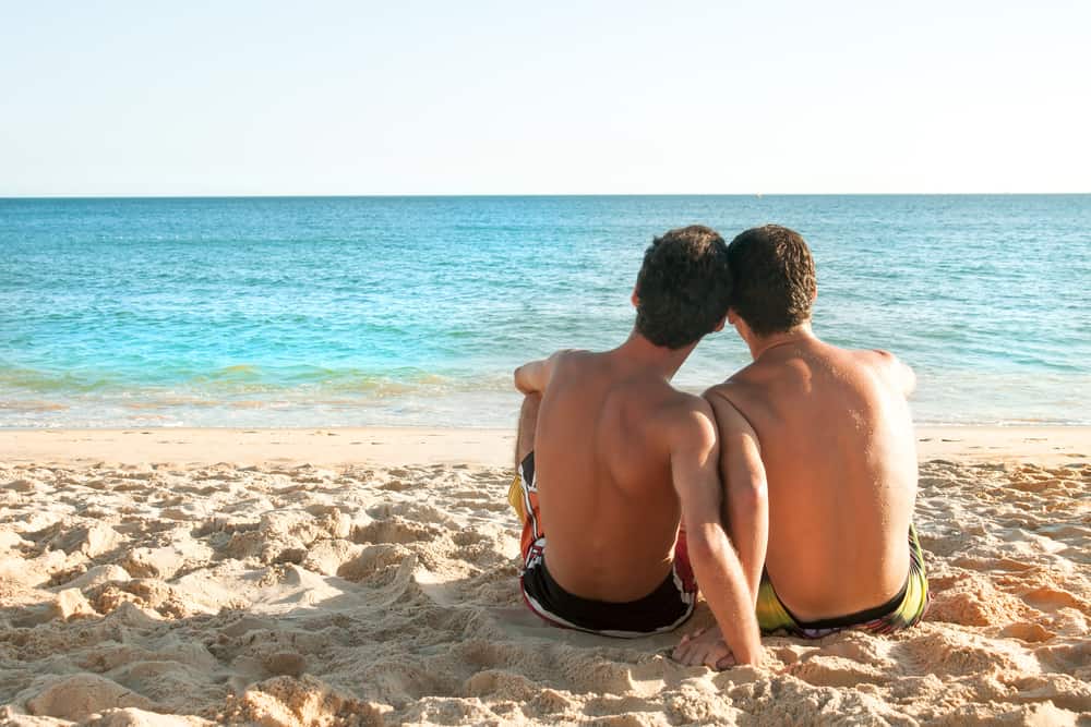 a gay couple cuddling on the beach