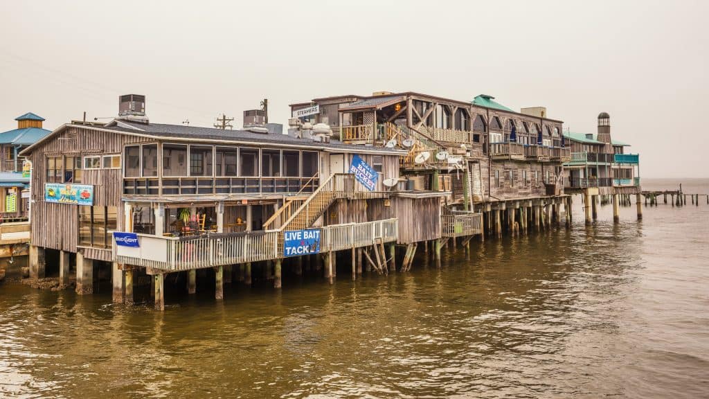 Fishing, bait, and tackle shops hover over the water on stilts in Cedar Key, Florida.