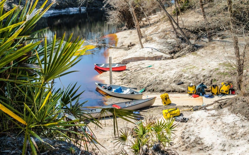 Canoes and backpacking gear sit ready on the shores of Stephen Foster Folk Culture State Park in White Springs, one of the cutest small towns in Florida.