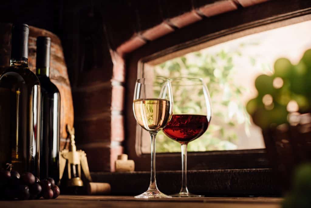 A glass of red and white wines sit in the window at one of the best wineries in Florida.