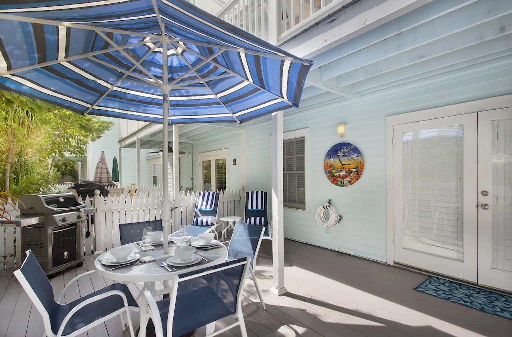 Photo of a Key West condo patio with lounge chairs and a dining table. 