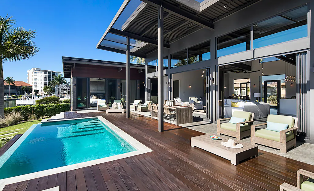 Photo of a waterfront villa with an infinity pool and large deck.