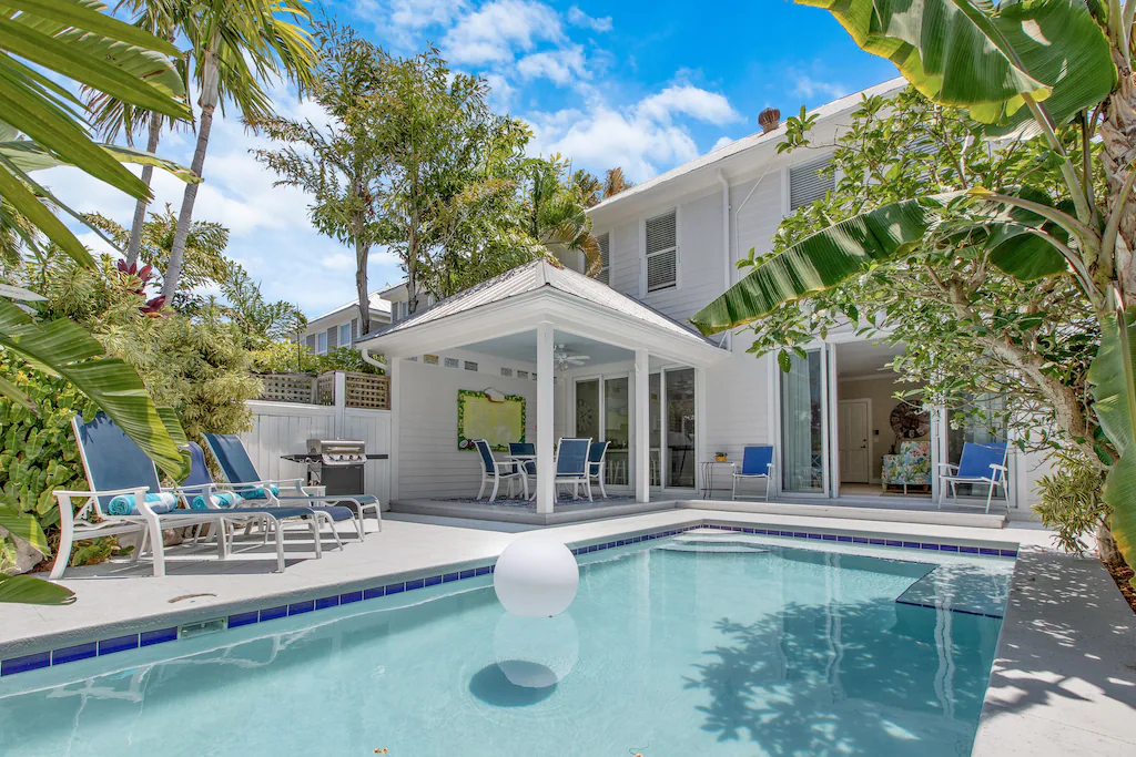 Photo of a vacation rental featuring a pool with covered lounge area. 