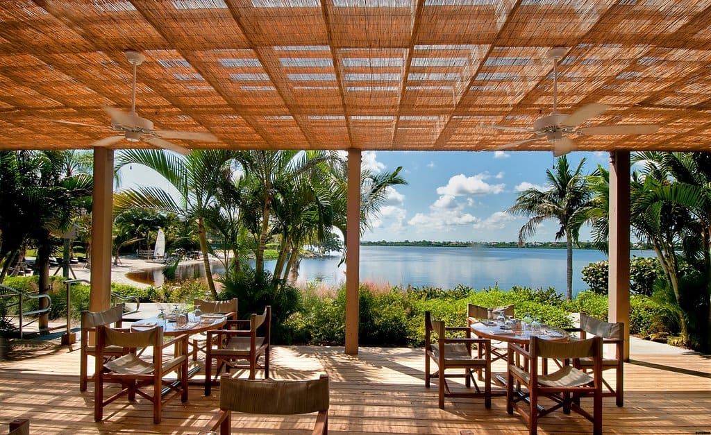 An outdoor dining area looking over water at one of the all inclusive resorts in Florida