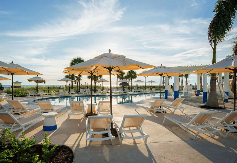 A beautiful swimming pool with yellow and white umberella at Sirata at one of the all inclusive resorts in Florida