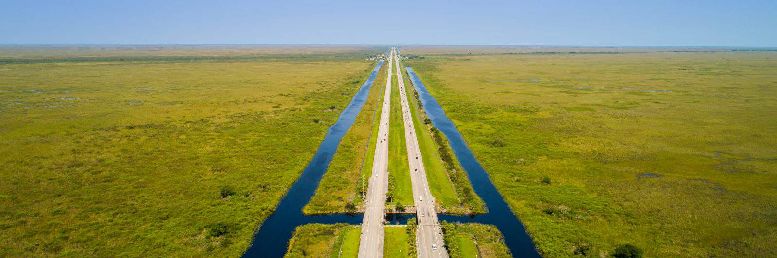 A drone captures the two lane highway of Alligator Alley in Florida.