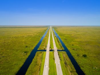A drone captures the two lane highway of Alligator Alley in Florida.