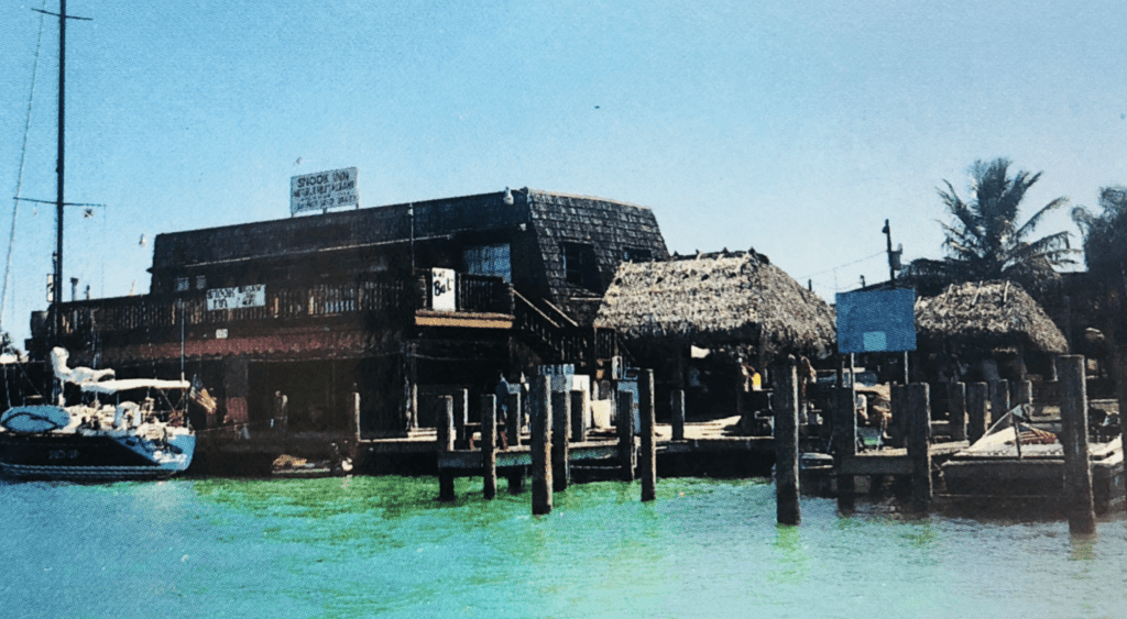 An old photo of the historic Snook Inn sitting on the water, one of the best restaurants in Marco Island.