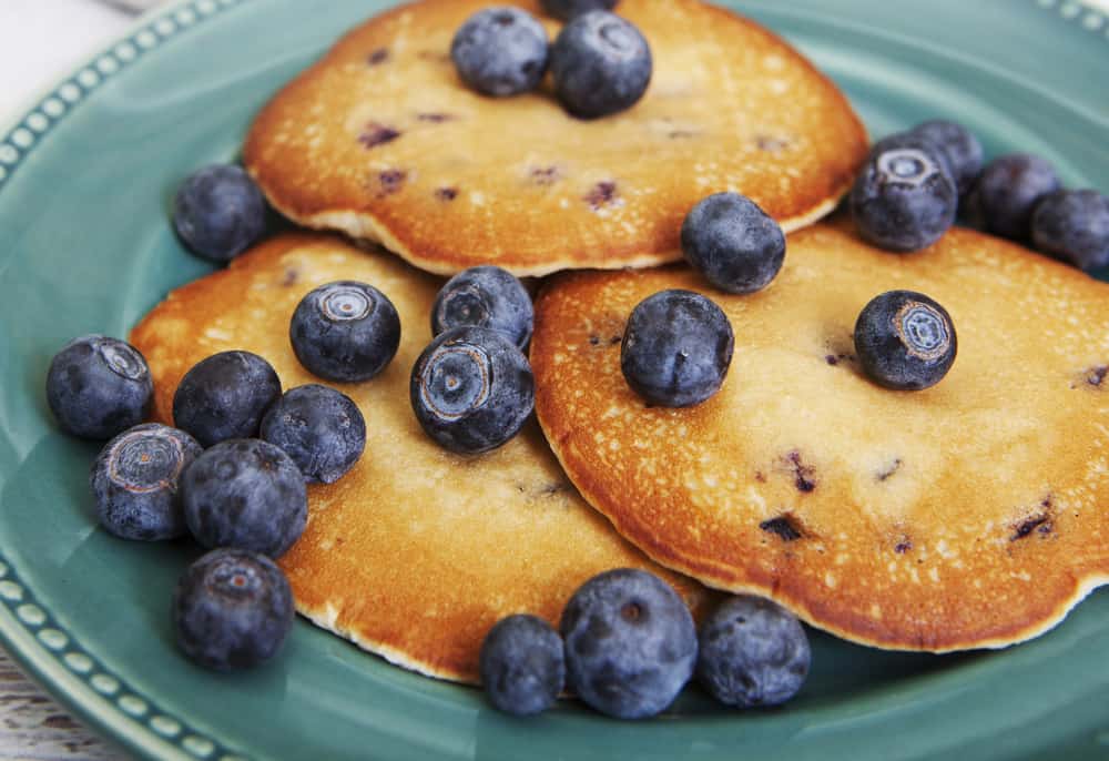 blueberry pancakes on a plate with syrup