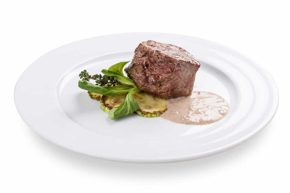 A filet steak with veggies and sauce