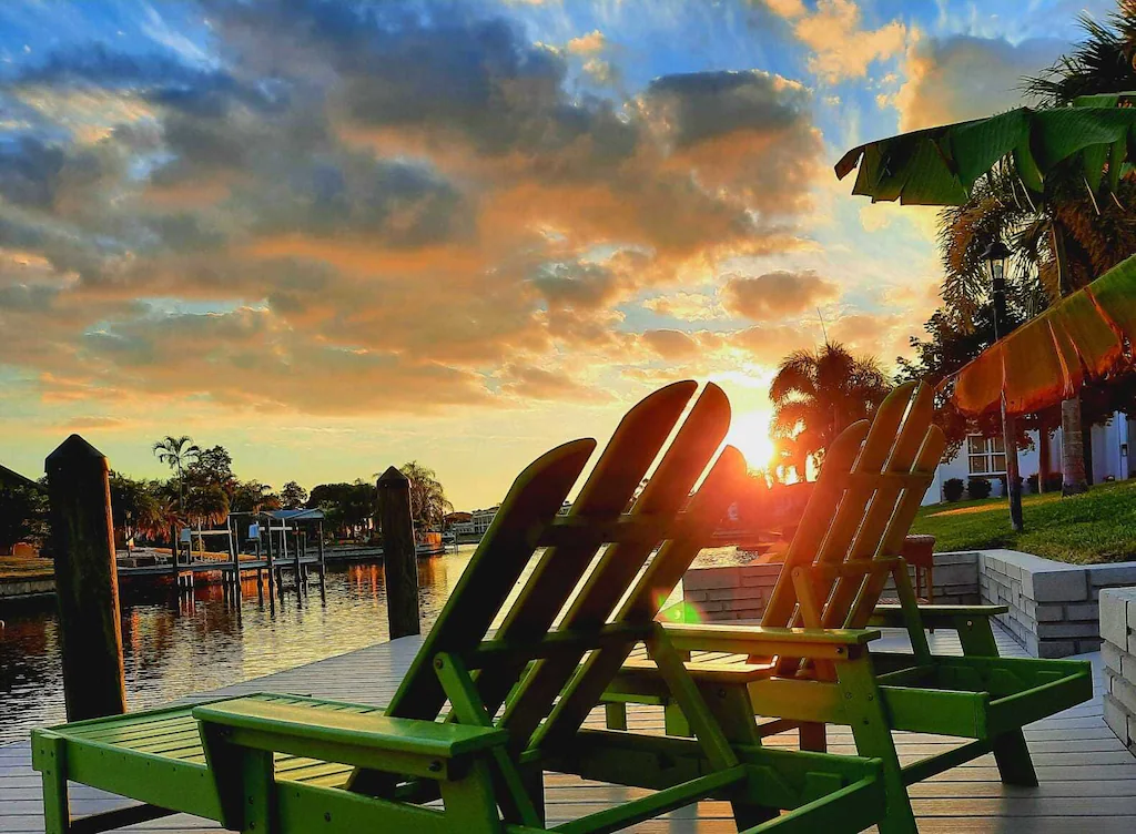 The sun sets on two chairs on the dock of the Villa Las Palmas, the best airbnb in Florida