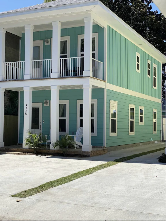This beautiful listing is painted a gorgeous seafoam green and looks like a true beach house.