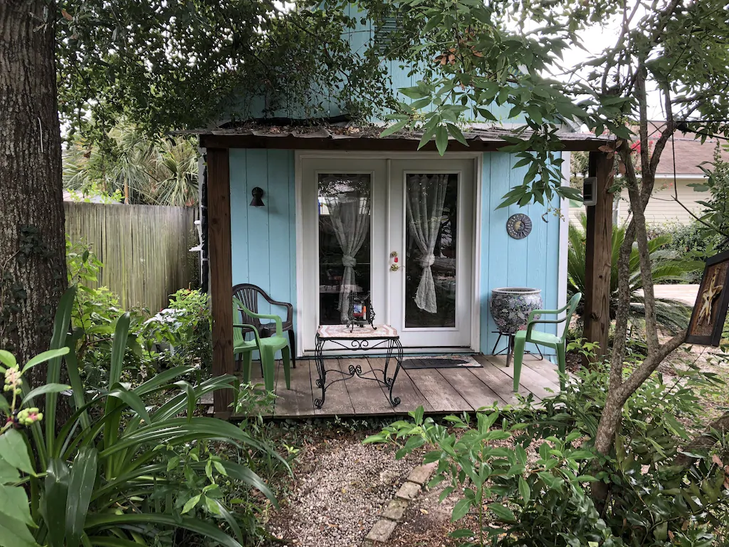 This listing, a gorgeous cottage, was hand-built by the owner. In a lush garden area, you'll love sitting on the small porch. 