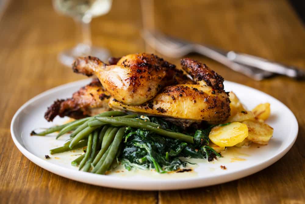 Chicken in a herb sauce with sautéed green beans and spinach with roasted potatoes